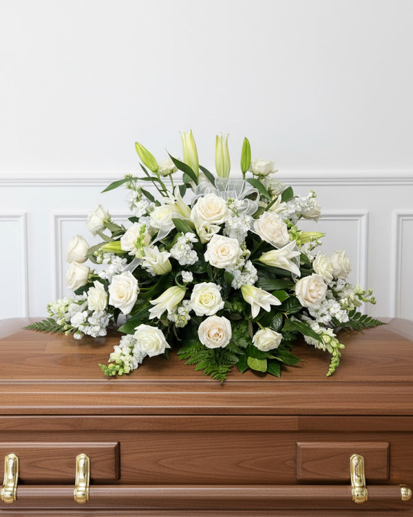 White Casket Spray — a casket spray of white roses, lilies, and hydrangea, timeless and comforting