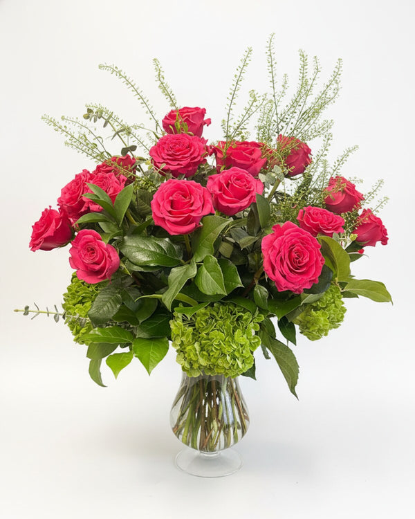 Pink & Green — hot pink roses over fresh green hydrangea with airy white accents, arranged in a flared glass vase.