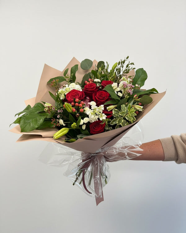 Red Ribbon — an arrangement of vibrant red blooms accented with fresh white flowers and lush greenery